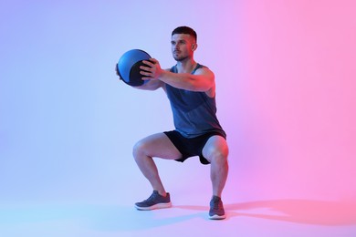 Photo of Man exercising with medicine ball on color background