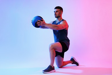 Photo of Man exercising with medicine ball on color background