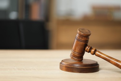 Photo of Judge's gavel on wooden table in office, closeup. Space for text