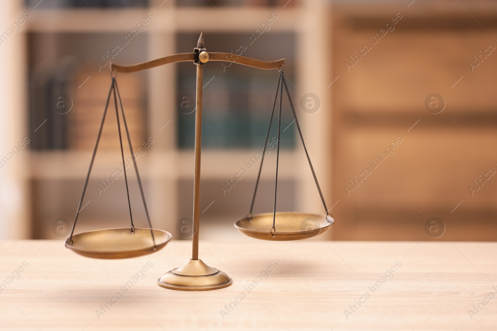 Scales of justice on wooden table in office, space for text Photo of Scales of justice on wooden table in office, space for text