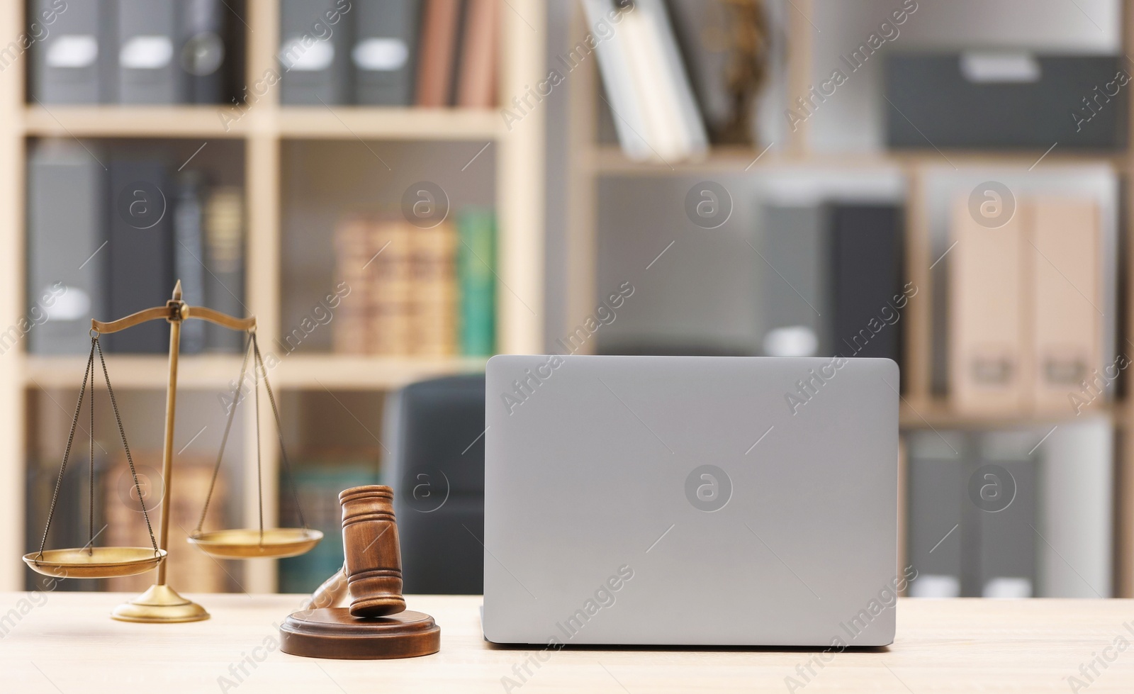 Judge's gavel, scales and laptop on wooden table in office Photo of Judge's gavel, scales and laptop on wooden table in office