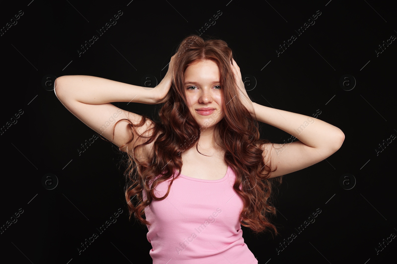 Portrait of beautiful teenage girl with healthy wavy hair on black background Photo of Portrait of beautiful teenage girl with healthy wavy hair on black background