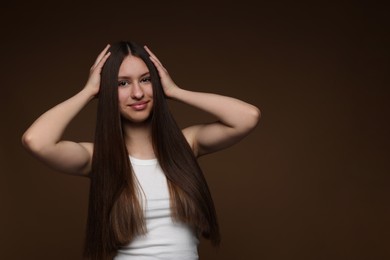 Photo of Portrait of beautiful teenage girl with healthy long hair on brown background. Space for text