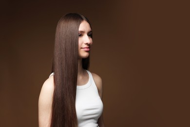 Photo of Beautiful teenage girl with healthy long hair on brown background. Space for text