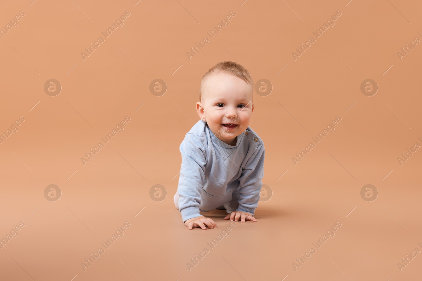 Cute little baby crawling on beige background Photo of Cute little baby crawling on beige background