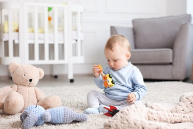 Photo of Cute little baby playing with toys in room