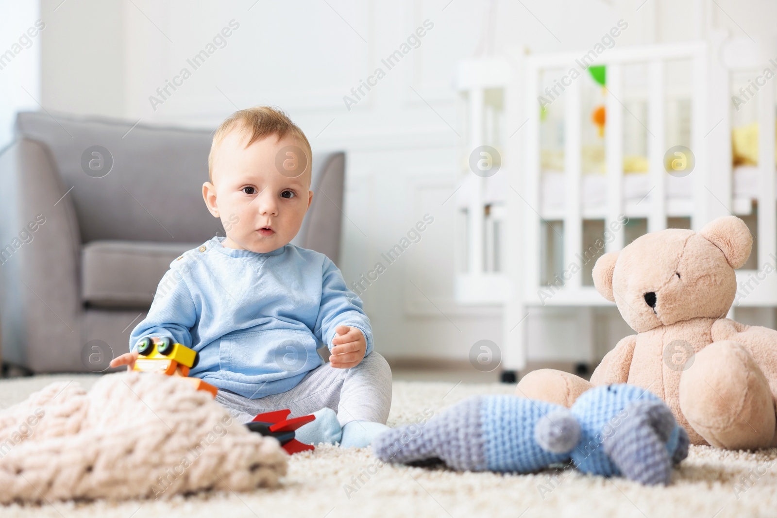 Cute little baby playing with toys in room Photo of Cute little baby playing with toys in room