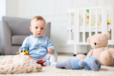 Photo of Cute little baby playing with toys in room