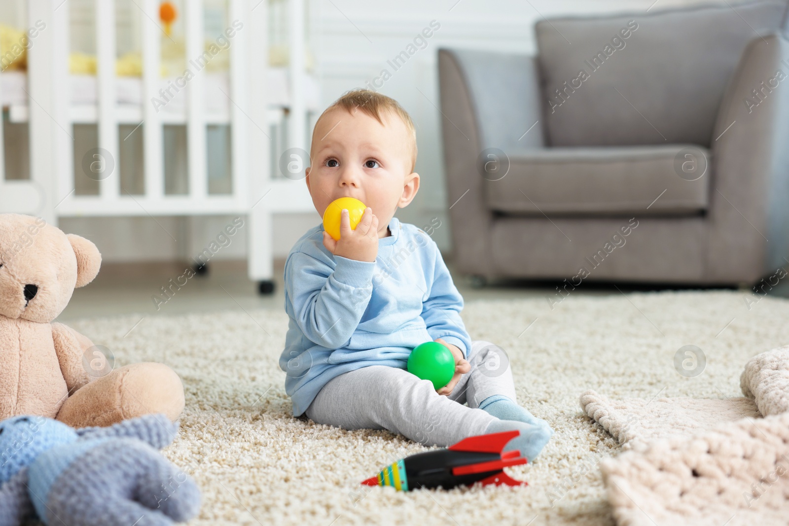 Cute little baby playing with toys in room Photo of Cute little baby playing with toys in room