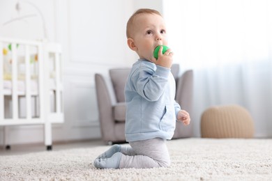 Photo of Cute little baby playing with toy in room