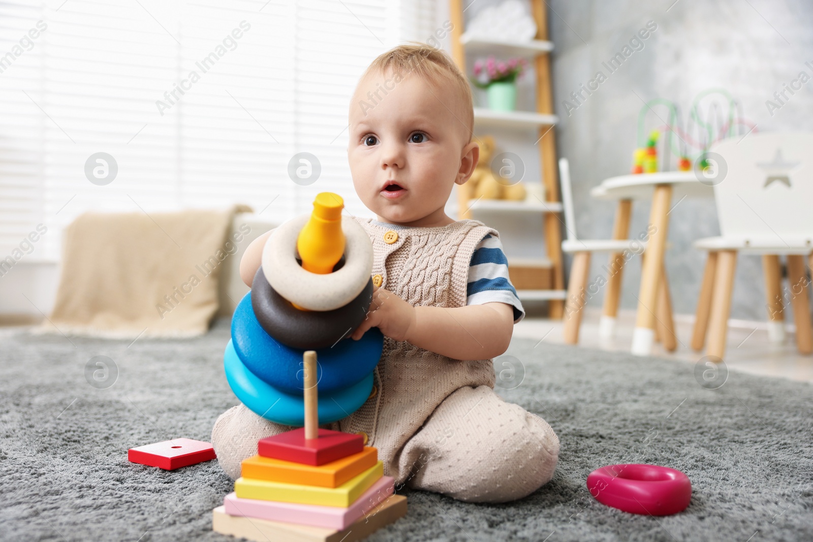 Cute little baby playing with toys in room Photo of Cute little baby playing with toys in room