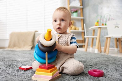 Photo of Cute little baby playing with toys in room
