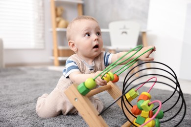Photo of Cute little baby playing with toy in room