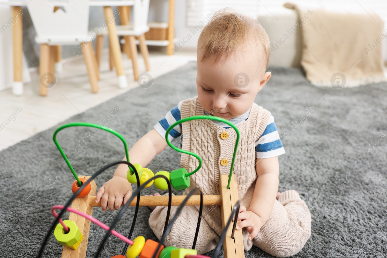 Cute little baby playing with toy in room Photo of Cute little baby playing with toy in room