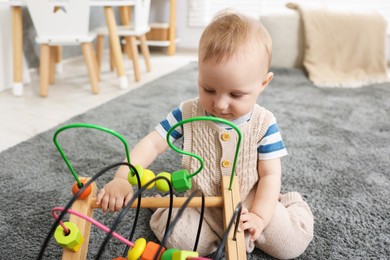 Photo of Cute little baby playing with toy in room