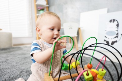 Photo of Cute little baby playing with toy in room