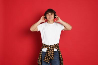 Photo of Teenage boy listening to music on red background