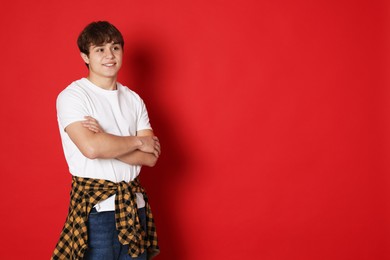 Photo of Portrait of teenage boy on red background. Space for text