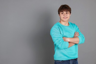 Photo of Portrait of teenage boy on grey background. Space for text