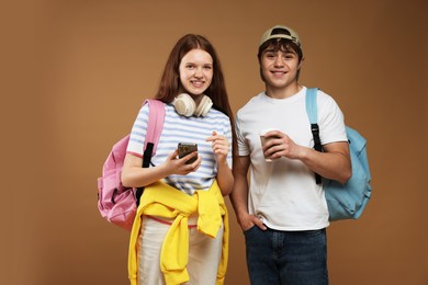 Photo of Teenagers with backpacks and drink on brown background