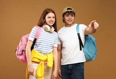 Photo of Teenage boy showing his friend something on brown background