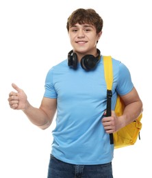 Photo of Teenage boy with headphones and backpack showing thumbs up on white background