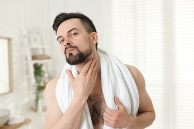 Photo of Portrait of handsome man before shaving in bathroom