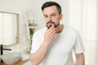 Photo of Portrait of handsome man before shaving in bathroom