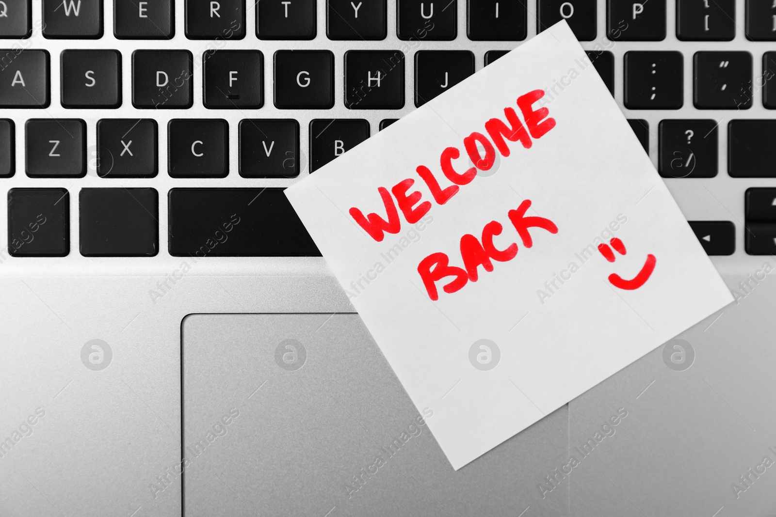 Paper note with words Welcome Back on laptop, top view Photo of Paper note with words Welcome Back on laptop, top view
