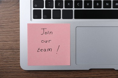 Photo of Paper note with words Join Our Team and laptop on wooden table, top view
