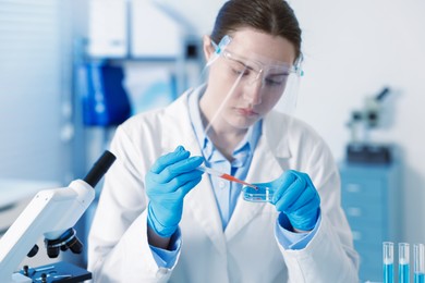 Photo of Scientist working with sample in Petri dish in laboratory, selective focus