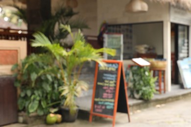 Photo of Blurred view of plants and restaurant sign outdoors