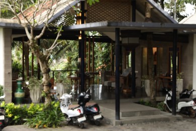 Photo of Blurred view of scooters parked near hotel
