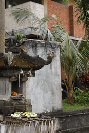 Photo of Different traditional balinese offerings on stone post