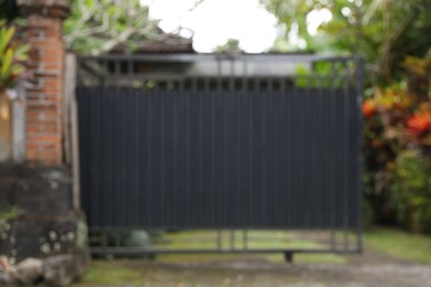 Photo of Blurred view of closed gate and green plants