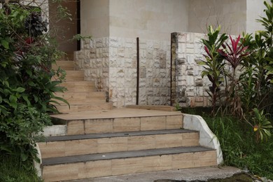 Photo of Different plants growing near stairs of hotel