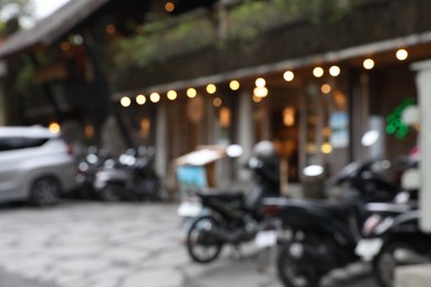 Photo of Blurred view of scooters parked near shop