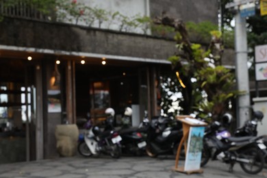 Photo of Blurred view of scooters parked near shop