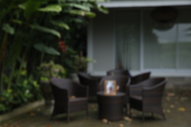 Photo of Blurred view of table with chairs near hotel