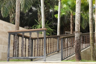 Photo of Bali, Indonesia - June 04, 2025: Pathway with railings and green palm trees