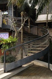 Photo of Bali, Indonesia - June 04, 2025: Metal stairs with railings and green plants outdoors