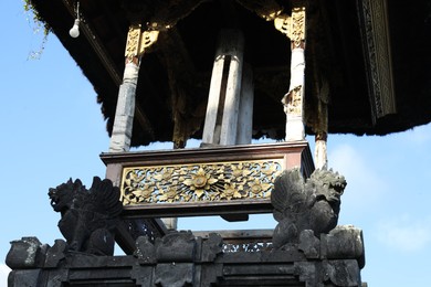 Photo of Bali, Indonesia - June 6, 2025: Beautiful temple with gate guardian statues outdoors, low angle view