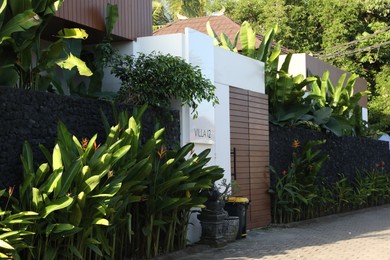 Photo of Beautiful villa and plants growing on city street