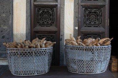 Photo of Baskets with raw sweet potatoes in market