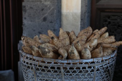 Photo of Basket with raw sweet potatoes in market, closeup