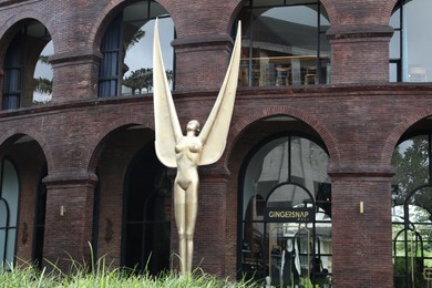 Photo of Bali, Indonesia - June 7, 2025: Beautiful building and golden statue on city street