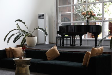 Photo of Bali, Indonesia - June 7, 2025: Stylish hotel room interior with piano and sofa