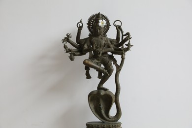 Photo of Bali, Indonesia - June 7, 2025: Beautiful Krishna statue with flower near white wall