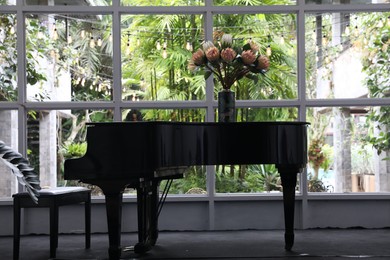 Photo of Bali, Indonesia - June 7, 2025: Vase with flowers on piano near window in hotel room