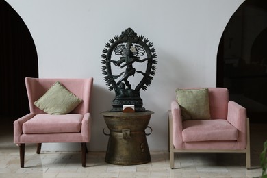 Photo of Bali, Indonesia - June 7, 2025: Stylish armchairs and Shiva Nataraja statue in hotel room